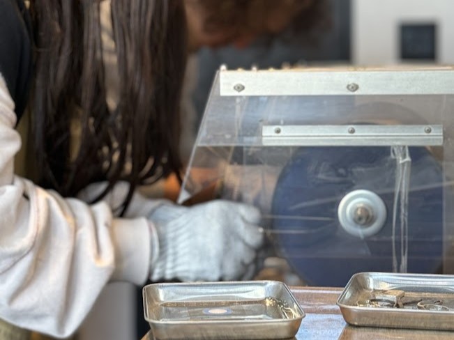 結婚指輪の仕上げ工程で、専用のバフ機を使いプラチナリングを鏡面仕上げに磨き上げる様子